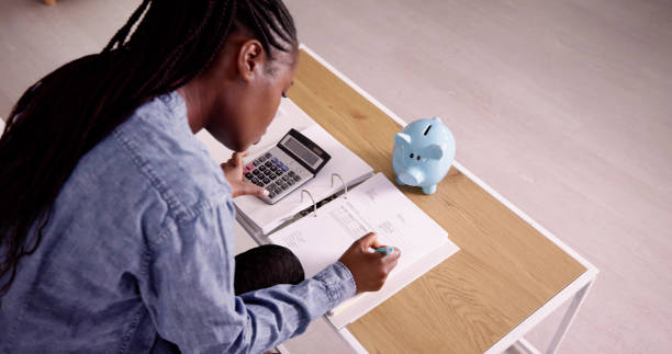 Young African Woman Calculating Invoice With Calculator